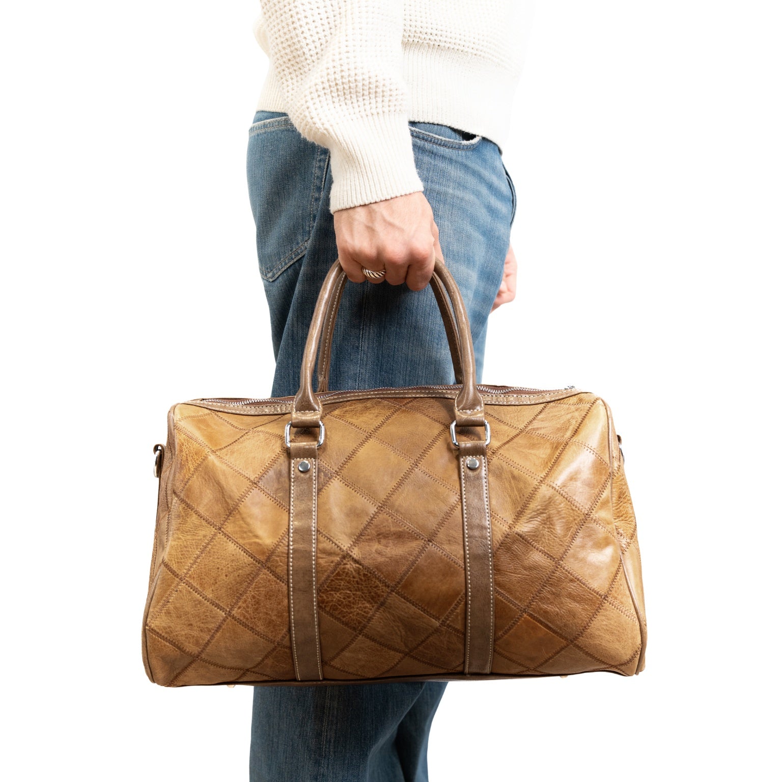 VUOTÍGA brown quilted leather bag held by a person wearing jeans and a white sweater on a white background